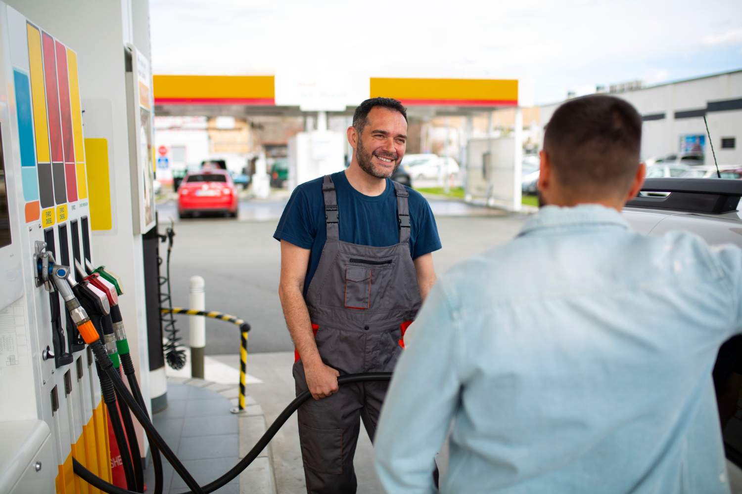 Fuel station attendant with customer outside