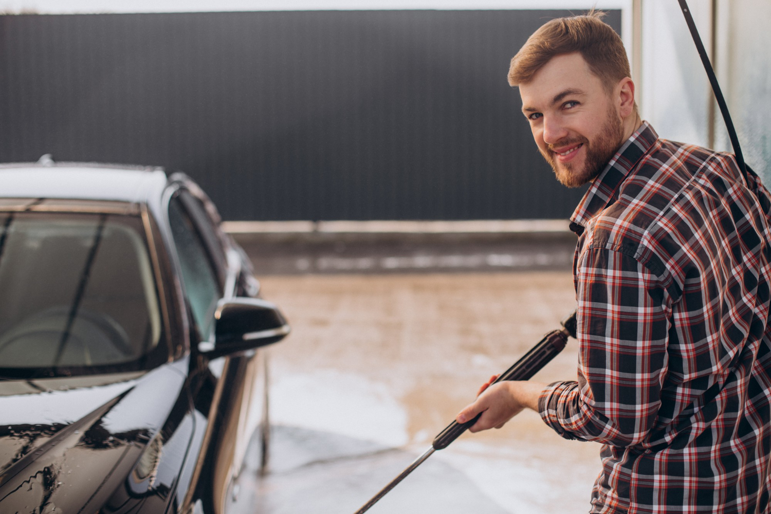 Man at car wash smiling at camera