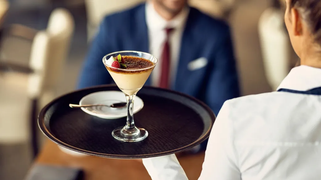 Closeup waitress serving dessert guest coffee