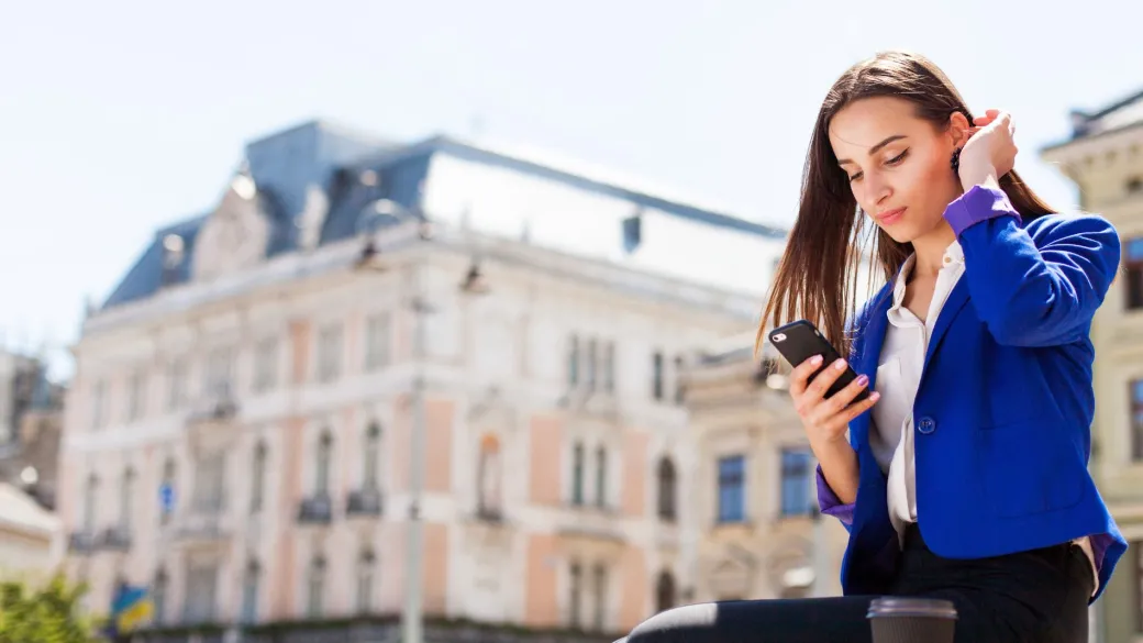 people redirect checkout woman checks her phone sitting with cup coffee street