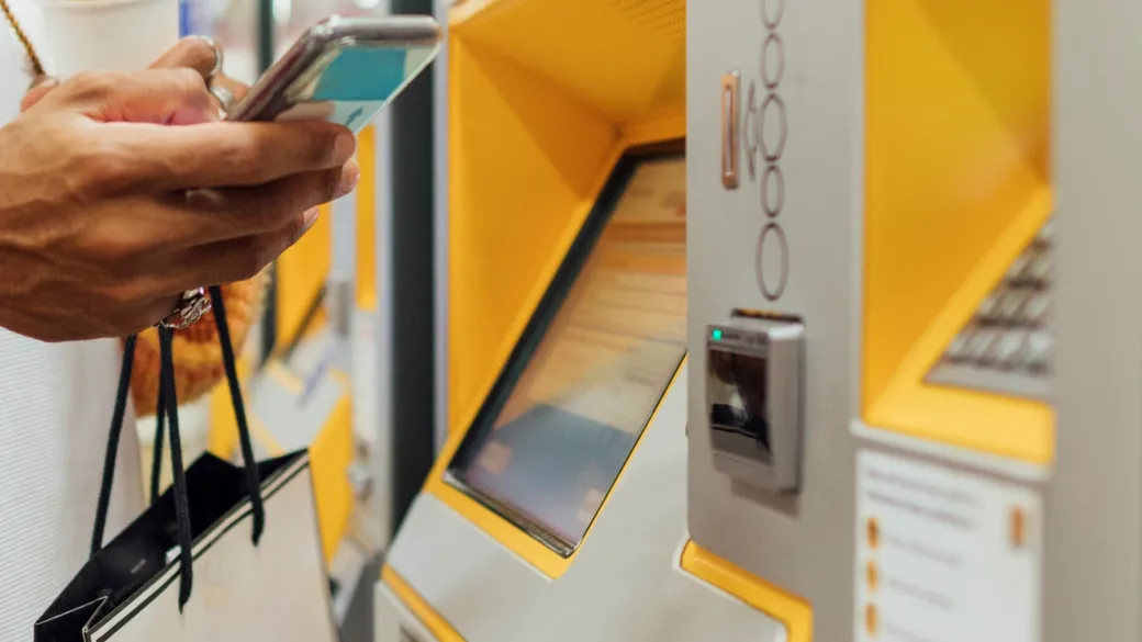 Person paying at a kiosk