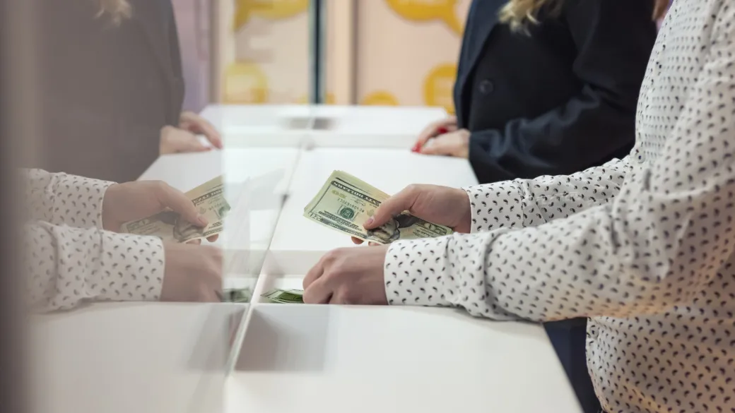 Teller at bank providing cash to customer