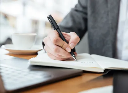 environmental-acquiring-services-businessman-sitting-by-table-writing-something