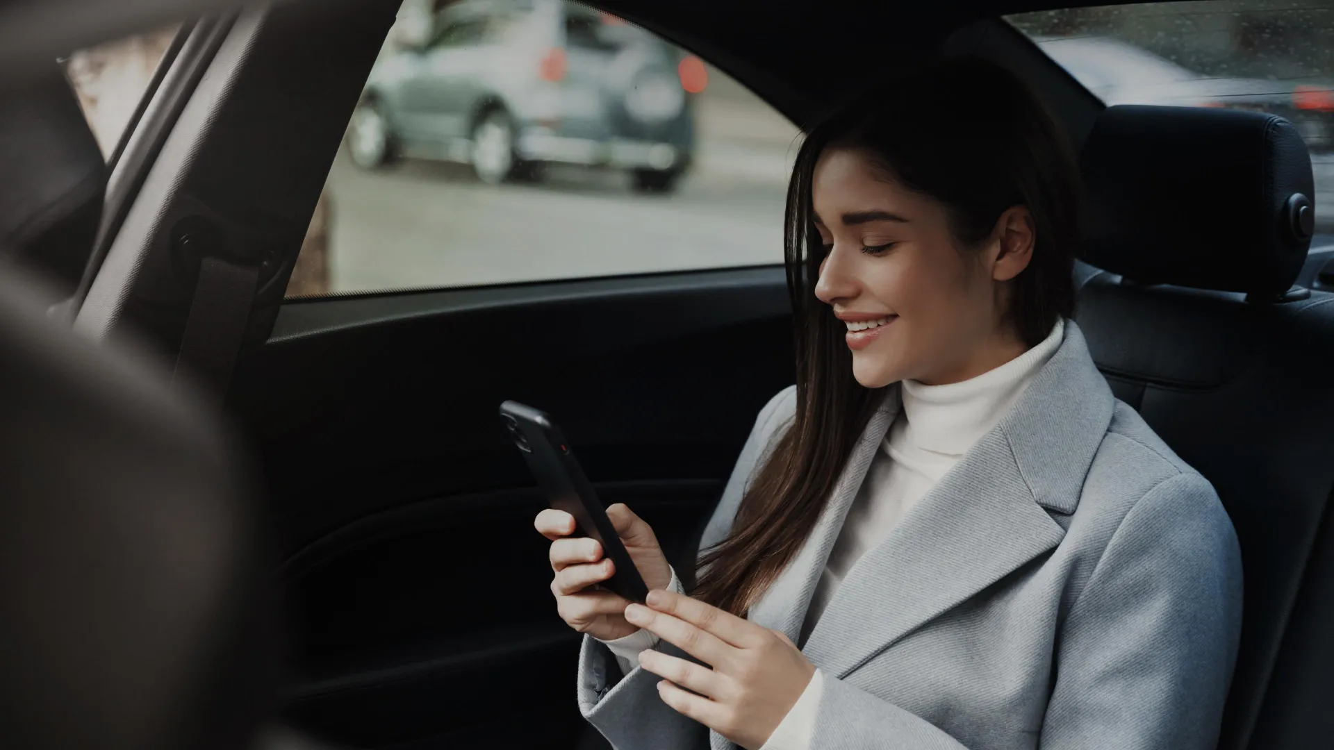 Business woman using mobile in taxi