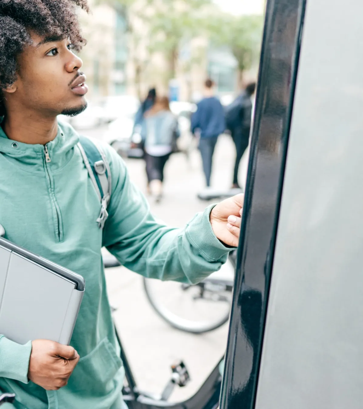young man paying at outdoor kiosk