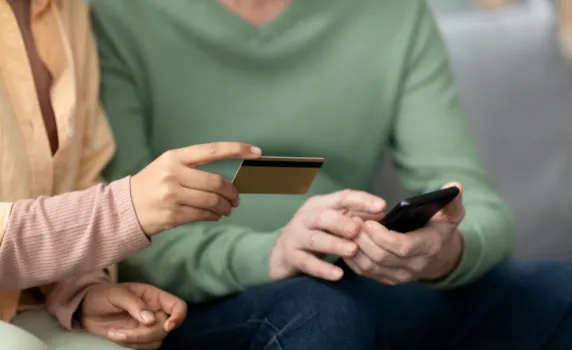 detail self service onboarding arabic woman teaching senior man use mobile pay