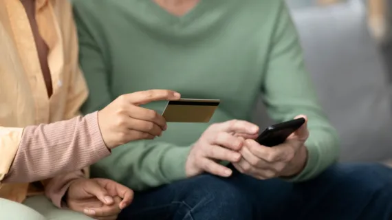 detail self service onboarding arabic woman teaching senior man use mobile pay